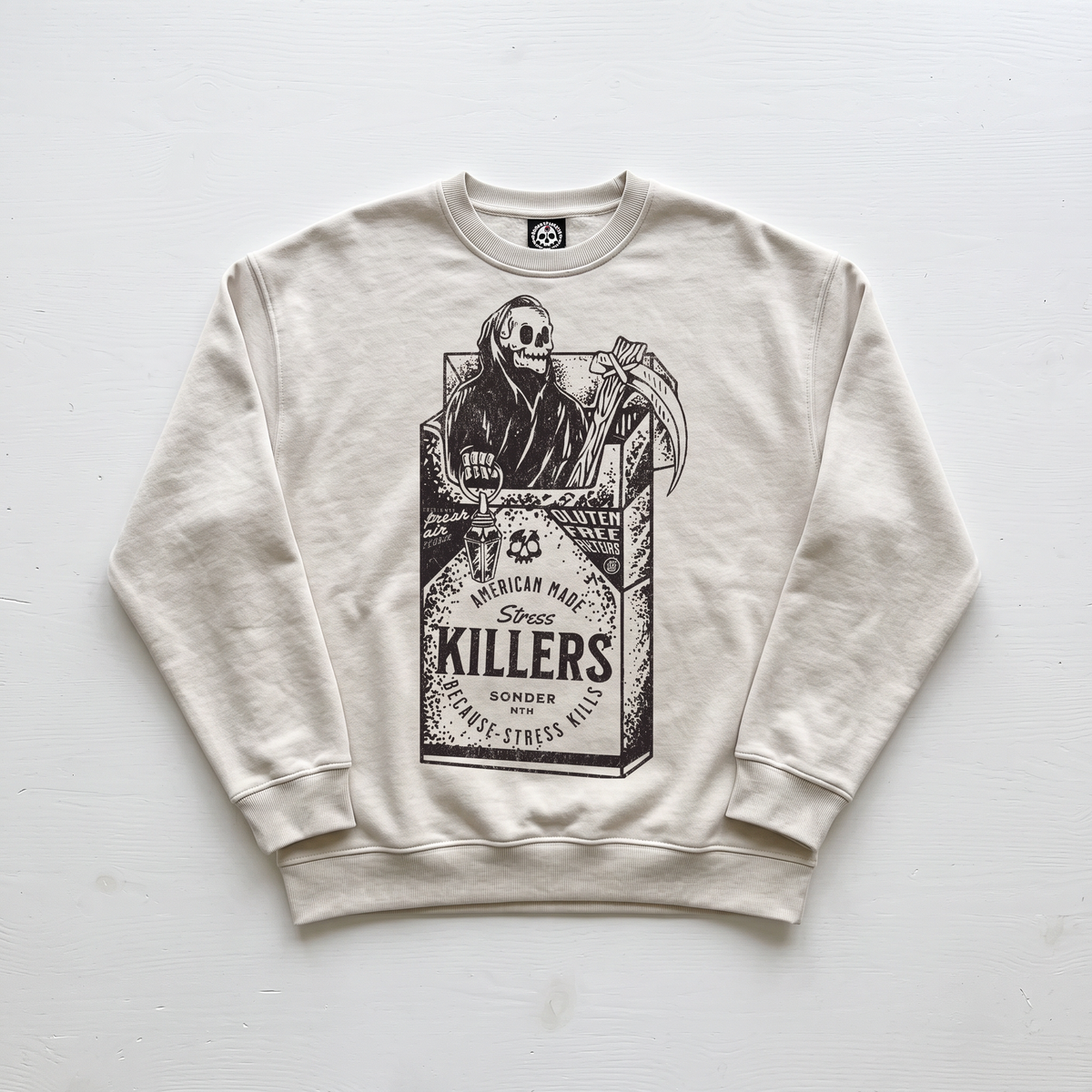 A cream-colored crewneck sweatshirt featuring a black graphic print of a skeleton in a cigarette pack labeled 'KILLERS'.