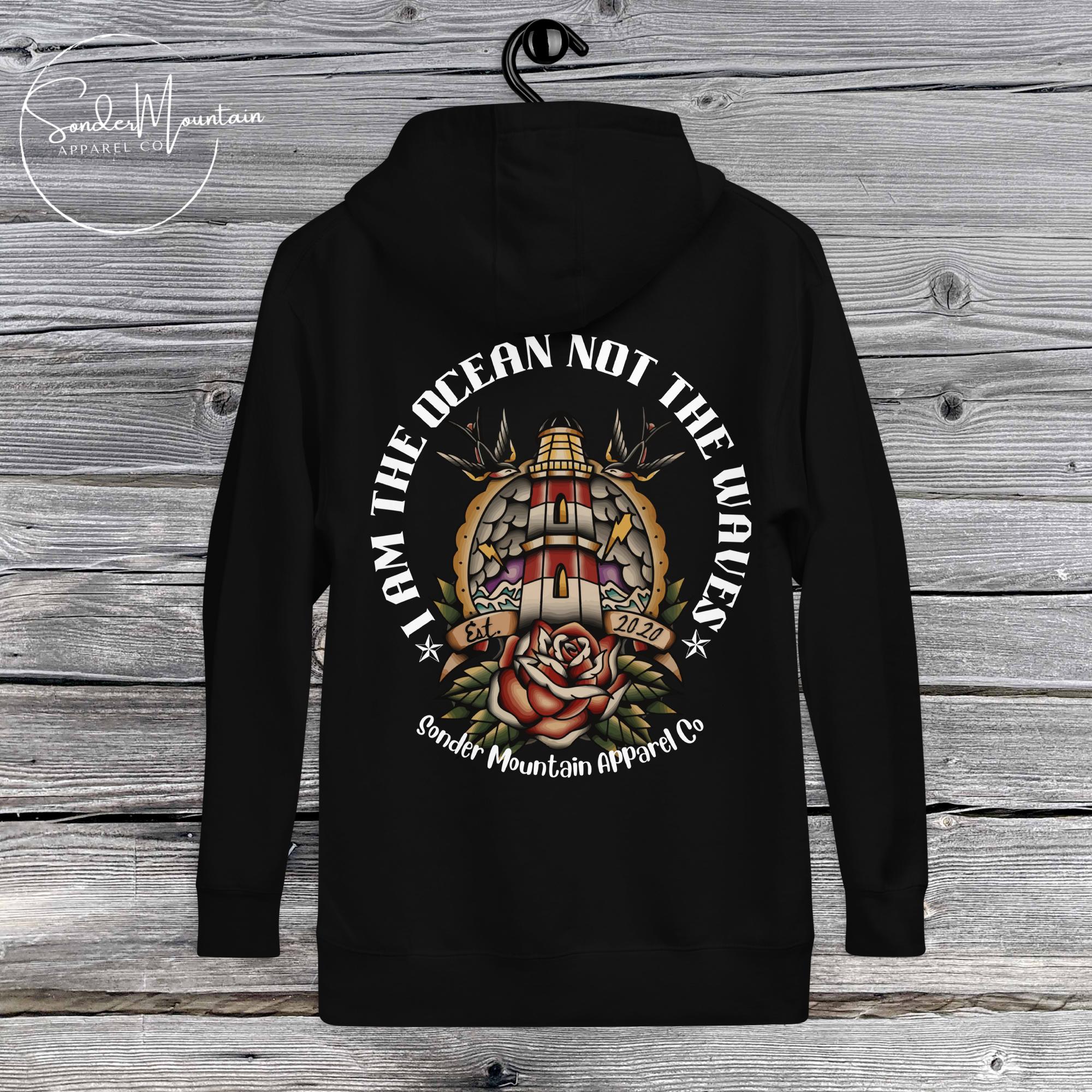 A black unisex hoodie with an ocean-themed graphic design, featuring text and various elements such as a lighthouse, waves, and a rose.