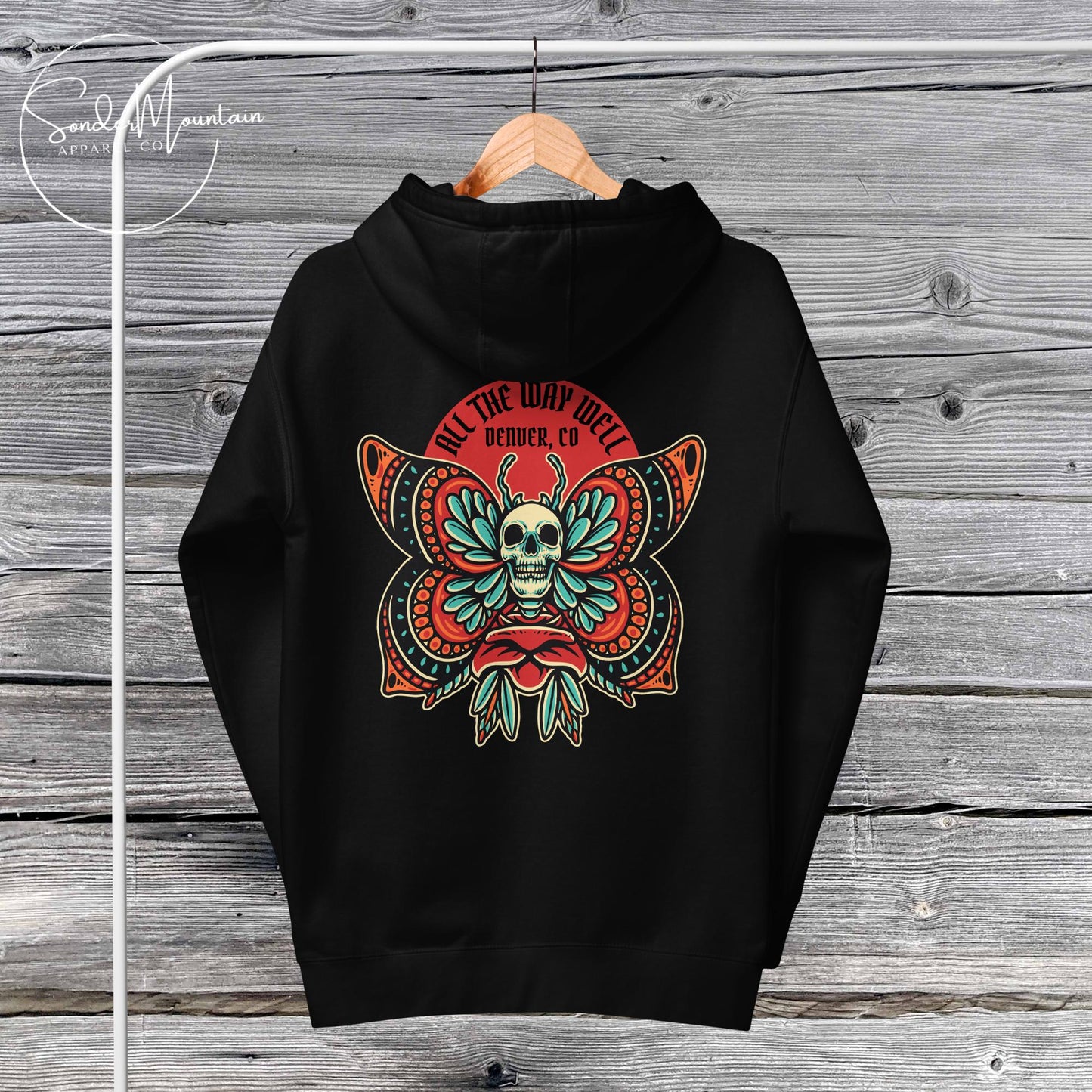 A black unisex hoodie with a graphic design featuring a skull, plants, and text on the front.