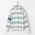A long-sleeve hooded sweatshirt with horizontal sage green and white stripes, featuring a small blue skull-and-crossbones emblem on the left chest and a matching sleeve patch, hanging on a wooden hanger against a white wall.