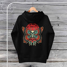 A black unisex hoodie with a graphic design featuring a skull, plants, and text on the front.
